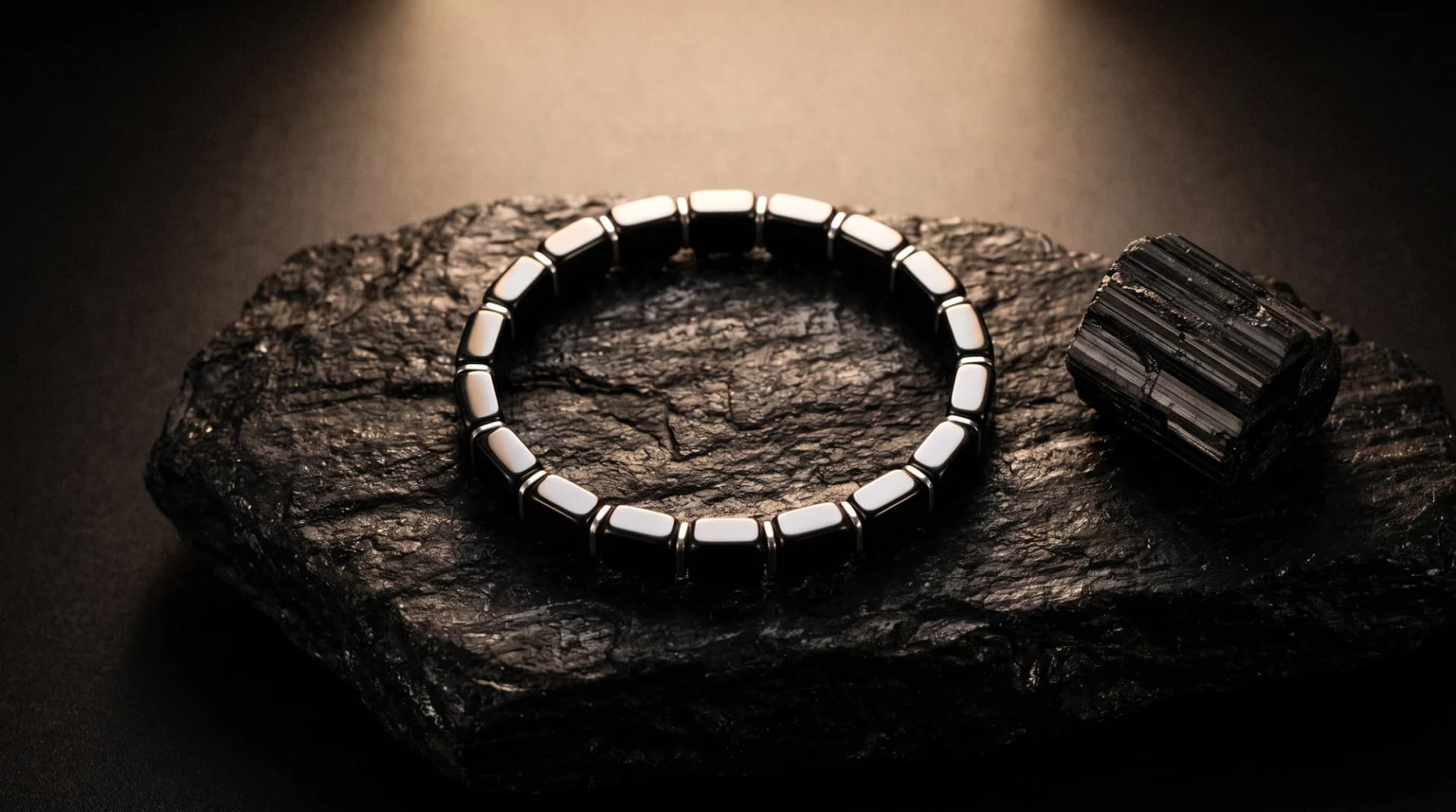 Hematite bracelet resting on a piece of dark stone